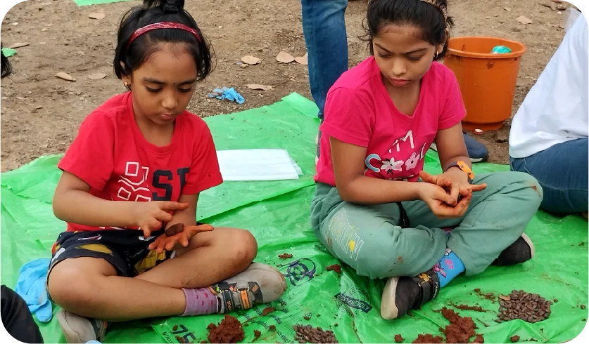 Child making seed balls during an environmental workshop